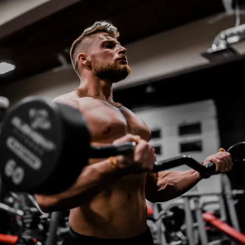 man utan tröja som lyfter vikter