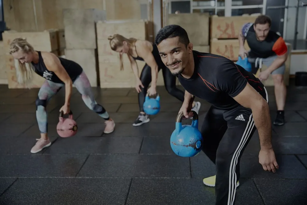 fyra människor tränar med kettlebells