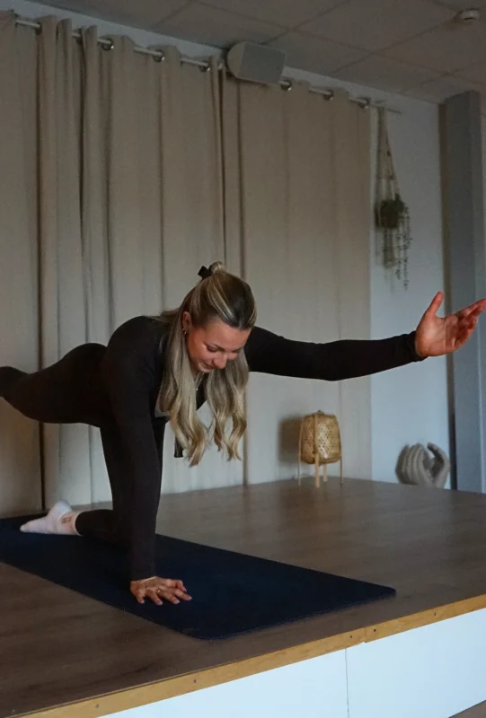 Hot pilates instruktör står i ställning på knä och armar